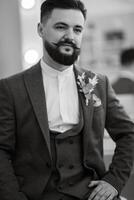 retrato do sorridente noivo com barba dentro cinzento cor terno foto