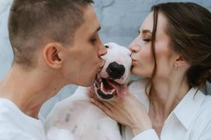 jovem casal cara e menina dentro uma brilhante quarto jogando com animal foto