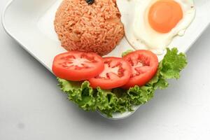 americano estilo café da manhã conjunto, frito arroz com frito frango ,salsicha e vegetal em branco prato foto