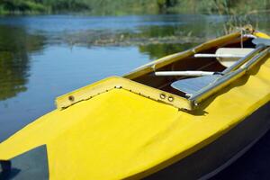 amarelo brilhante caiaque mentiras em a banco do a oskol rio. foto