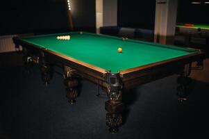 de bilhar mesa com verde superfície e bolas dentro a de bilhar clube. foto