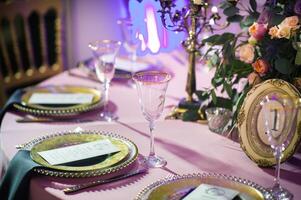 decoração do a festivo jantar com rosa flores em a Casamento mesa dentro a interior do a restaurante. decorado mesa para celebração foto