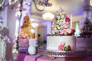 branco Casamento bolo decorado com creme flores em uma ficar de pé foto