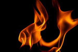 quente chamas em uma Preto fundo. lindo chama do fogo dentro a escuro. abstrato do queimando chamas e fumaça. foto