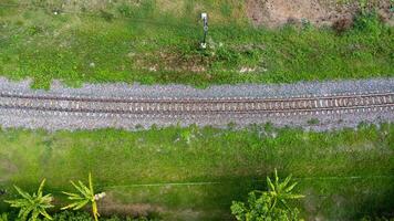 aéreo Visão do a estrada de ferro dentro a parque. topo Visão do a Ferrovia a partir de uma drone. trem faixas dentro rural cena foto