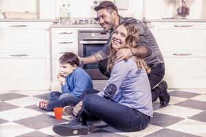 família relaxante em chão dentro a cozinha foto