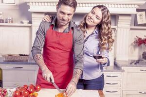 bonita jovem casal ter Diversão dentro moderno cozinha foto