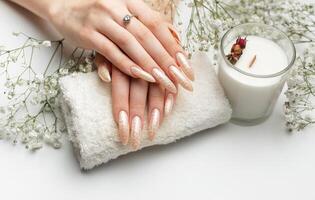 a unhas estão coberto com pérola gel polonês em branco fundo foto