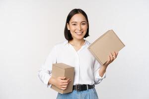 conceito do compras e Entrega. jovem feliz ásia mulher posando com caixas e sorridente, em pé sobre branco fundo foto