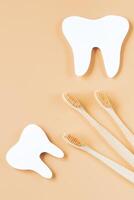 ecológico de madeira escovas de dente em na moda bege fundo. dental Cuidado conceito. feliz dentista dia. foto
