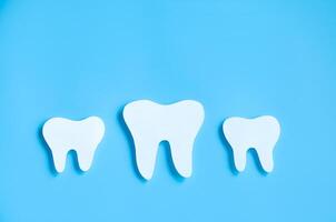 papel cortar brincar do dente em azul fundo. dental Cuidado conceito. internacional dentista dia. foto