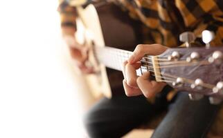 uma jovem homem jogando com acústico guitarra foto