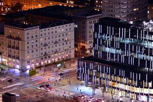 Visão do às noite vidro edifícios e moderno o negócio arranha-céus. Visão do moderno arranha-céus e o negócio edifícios dentro centro da cidade. grande cidade às noite. foto