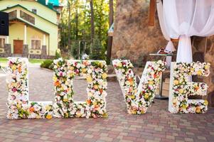 decorado para Casamento cerimônia. palavra amor decorado do flores às Casamento cerimônia foto