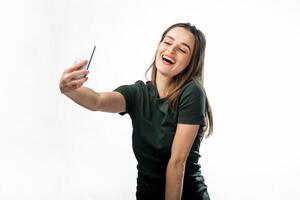 feliz paquera jovem menina levando As fotos do ela mesma através célula telefone, sobre branco fundo. lindo sorridente menina com grandes cabelo fazer selfie.