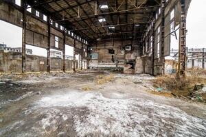 estragado fábrica dentro com muitos buracos e arruinado teto. velho fábrica fundo construção depois de tremor de terra desastre ou guerra. foto