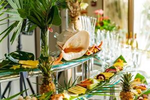 belas decorado delicioso mesa com fresco exótico orgânico frutas em uma bufê mesa para uma festa guloseimas. sortido diversidade do fresco exótico frutas. foto