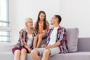 sorridente jovem pais e seus criança estão muito feliz, elas estão às casa foto