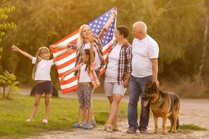 família posando ao ar livre com americano bandeira foto