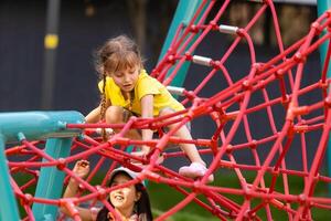 jovem meninas cutucando cabeça através escalada corda atividade usando isto Como quadro. foto