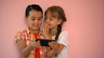 feliz pequeno meninas com uma Smartphone dentro mãos comunicar às casa com Amado uns usando moderno tecnologia foto
