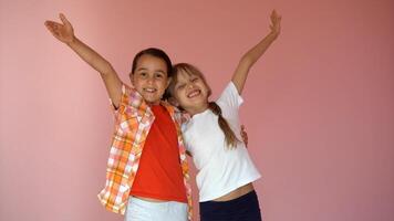 dois feliz meninas abraçando cada de outros isolado em Rosa fundo foto