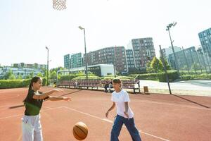 adolescente menina rua basquetebol jogador com bola em ao ar livre cidade basquetebol tribunal. foto