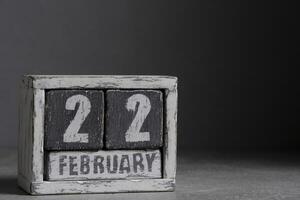 fevereiro 22 em de madeira calendário, em Sombrio cinzento fundo. foto