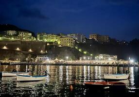 barcos dentro a Porto às noite com edifícios dentro a fundo foto