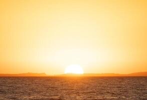 uma barco é Navegando dentro a oceano às pôr do sol foto