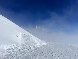 uma esquiador é em pé em a neve coberto declive foto