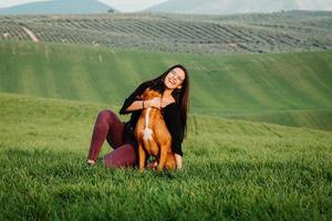 linda mulher brincando com seu cachorro. retrato ao ar livre. foto