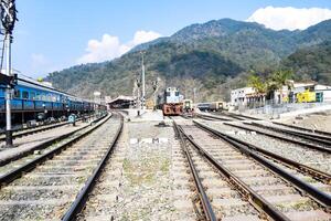 Visão do trem estrada de ferro faixas a partir de a meio durante dia às Kathgodam estrada de ferro estação dentro Índia, brinquedo trem rastrear visualizar, indiano estrada de ferro junção, pesado indústria foto