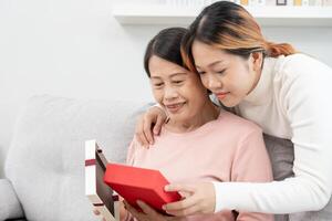 mãe dia, fofa ásia adolescente menina dar presente caixa para maduro meio era mãe. amor, beijo, Cuidado, feliz sorrir apreciar família tempo. a comemorar especial ocasião, feliz aniversário, feliz Novo anos, alegre Natal foto