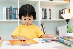 feliz ásia crianças relaxar ler livro às lar. filha e lendo uma história. aprender desenvolvimento, puericultura, rindo, Educação, narrativa, prática, Imagine, reduzir vício Móvel telefone foto