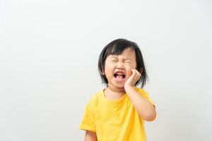 pequeno ásia menina prensas mão para bochecha, sofre a partir de dor dentro dente. dentes decair, dental problemas, criança emoções e facial expressão, oral saúde Cuidado, reduzindo doces, flúor Revestimento foto