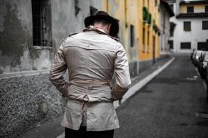 detetive caminhando dentro a cidade favelas, Visão a partir de a costas foto