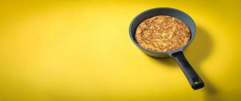 tortilla de patatas em fundo amarelo, prato típico espanhol. copie o espaço para o texto e vista superior foto