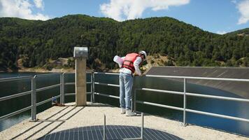 engenheiro inspeciona barragem projeto em a sacada foto