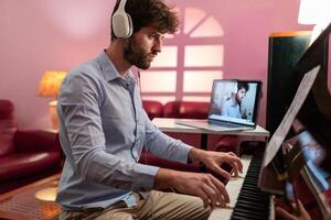 homem com fone de ouvido ensino piano música lição com controlo remoto vídeo transmissão foto