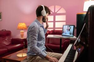 homem ensino piano música lição com controlo remoto vídeo transmissão foto