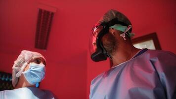 médico funcionários dentro emergência cirúrgico quarto com vermelho alarme foto