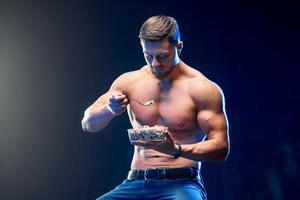 jovem muscular segurando saudável Comida. dieta e saudável comendo vigarista foto