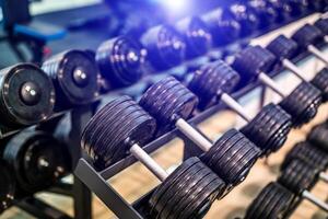 linhas do halteres dentro a Academia com borrado fundo. fechar-se. esporte equipamento. saudável vida conceito. foto