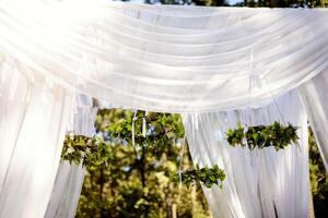 lindo Casamento arco para a cerimônia dentro a jardim dentro ensolarado clima foto