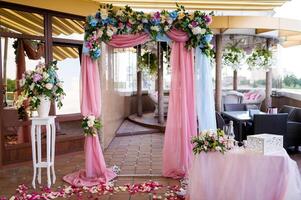 arco para a Casamento cerimônia, decorado pano flores vegetação foto