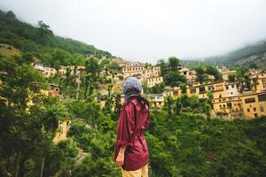 turista mulher ficar de pé apreciar cênico masuleh Vila panorama dentro norte leste Eu corri - popular famoso turismo destino dentro Pérsia foto