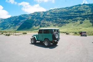 aéreo Visão do montar bromo savana área cheio do turistas, que começa para virar verde e fresco dentro a chuvoso estação em uma ensolarado manhã foto