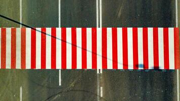 topo Visão do brilhantemente pintado vermelho e branco listras em a estrada para cruzando a rua. pedestre faixa de pedestre sem pessoas. a conceito do segurança em a estrada foto
