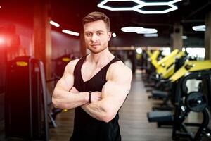 Atlético muscular homem posando para Câmera. musculação treinador dentro a academia. foto